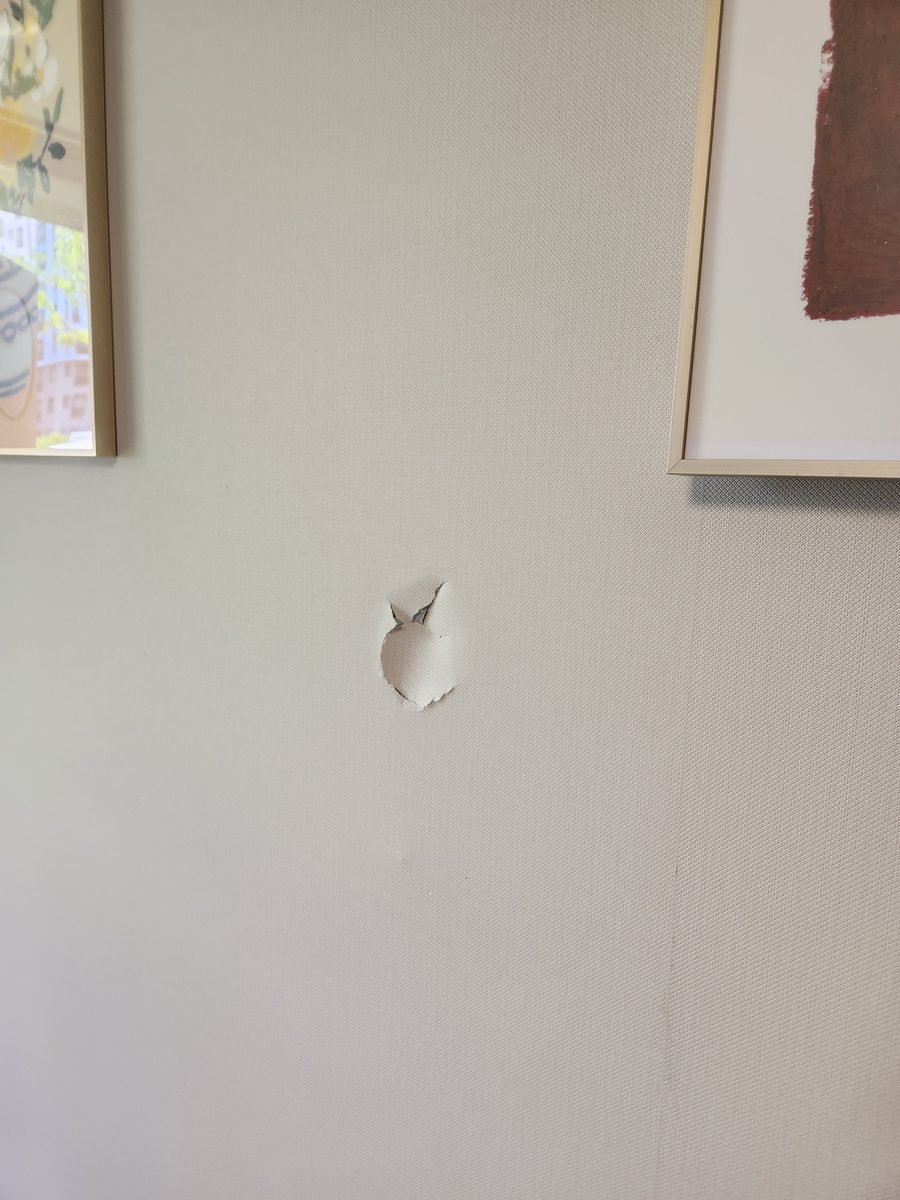 거실 액자 사이 벽에 구멍이 나고 벽지가 찢어진 상태 - 작업 전